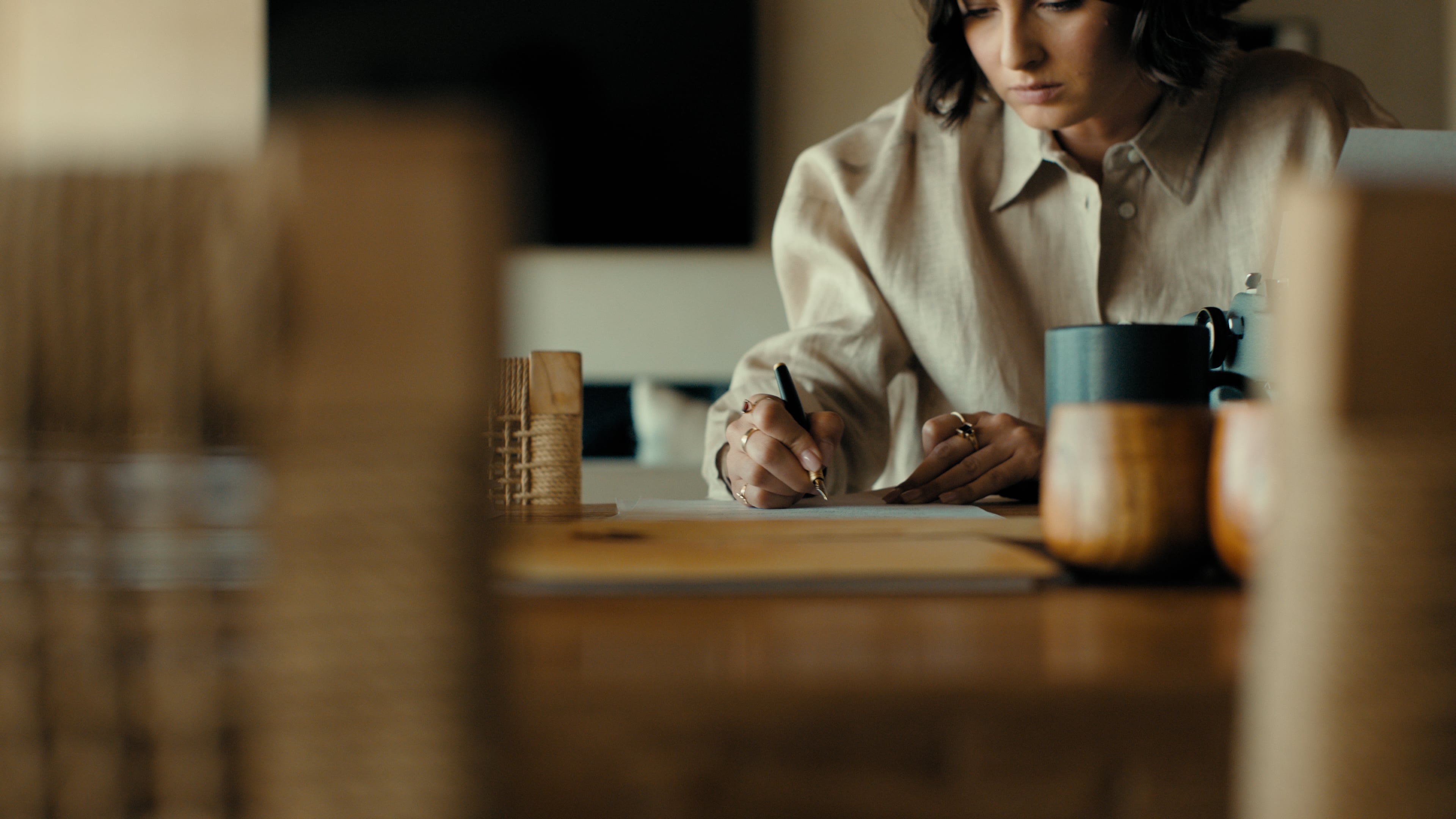 A women writes on a wooden desk